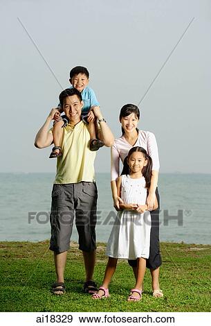 Family of four, standing by sea, family portrait View Large Photo Image Stock Photo - Family of four, standing by sea, family portrait. Fotosearch