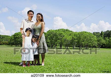 Family of four standing in field, looking at camera View Large Photo Image Stock Photo - Family of four standing in field, looking at camera. Fotosearch