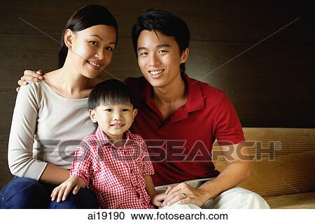 Stock Image - Family of three, smiling at camera. Fotosearch