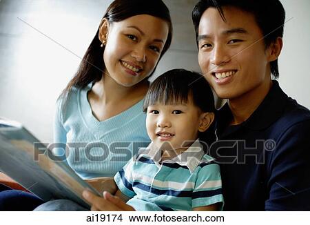 Family smiling at camera, father holding a book View Large Photo Image Picture - Family smiling at camera, father holding a book. Fotosearch