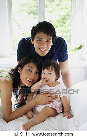 Family with one child, looking at camera View Large Photo Image Stock Image - Family with one child, looking at camera. Fotosearch