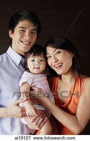 Stock Photo - Family with one child, looking at camera, portrait. Fotosearch