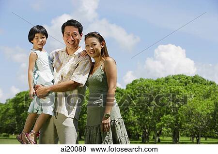 Stock Photo - Family with one child outdoors, portrait. Fotosearch