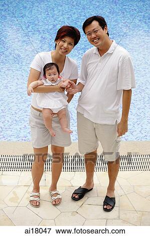 Family with one child, standing by swimming pool View Large Photo Image Stock Photo - Family with one child, standing by swimming pool. Fotosearch