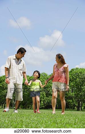 Family with one child walking in park, holding hands View Large Photo Image Stock Image - Family with one child walking in park, holding hands. Fotosearch