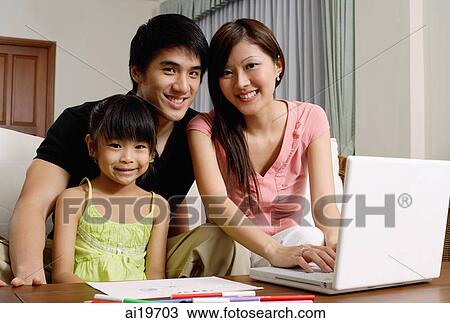 Family with one daughter, looking at camera, mother using laptop View Large Photo Image Stock Image - Family with one daughter, looking at camera, mother using laptop. Fotosearch