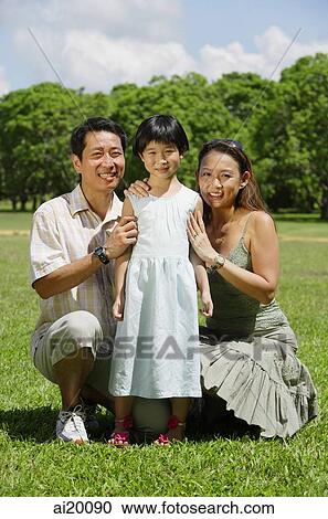 Father and mother crouching on either side of daughter, portrait View Large Photo Image Stock Image - Father and mother crouching on either side of daughter, portrait. Fotosearch