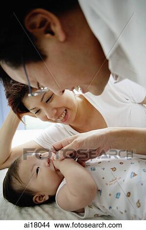 Father and mother looking at baby girl View Large Photo Image Picture - Father and mother looking at baby girl. Fotosearch