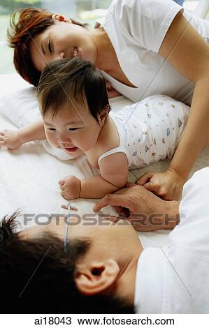 Father and mother lying down, baby girl between them View Large Photo Image Stock Image - Father and mother lying down, baby girl between them. Fotosearch