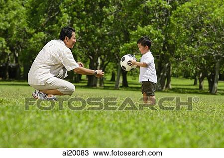 Father and young son in park with soccer ball View Large Photo Image Stock Image - Father and young son in park with soccer ball. Fotosearch