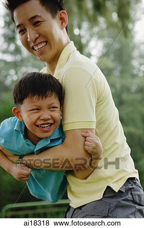 Father carrying son, both smiling View Large Photo Image Stock Photo - Father carrying son, both smiling. Fotosearch