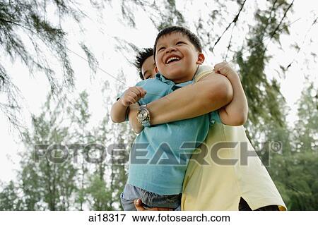 Stock Photo - Father carrying son, low angle view. Fotosearch