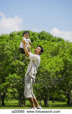 Father lifting son in the air, both looking at camera View Large Photo Image Stock Photography - Father lifting son in the air, both looking at camera. Fotosearch