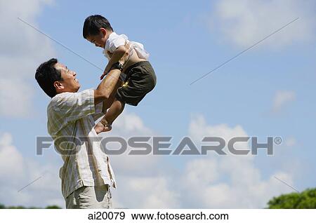Father lifting son in the air, side view View Large Photo Image Stock Photo - Father lifting son in the air, side view. Fotosearch