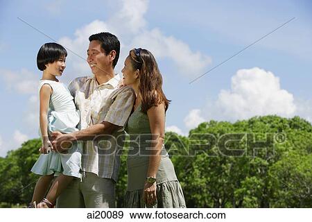 Stock Photo - Father, mother and daughter, standing outdoors. Fotosearch