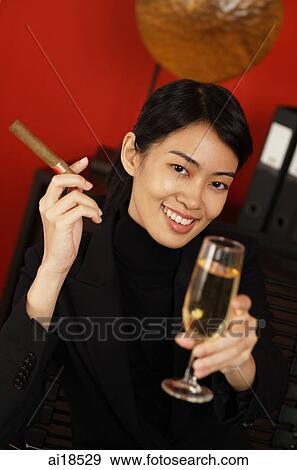 Female executive holding cigar and champagne glass, smiling View Large Photo Image Stock Photo - Female executive holding cigar and champagne glass, smiling. Fotosearch