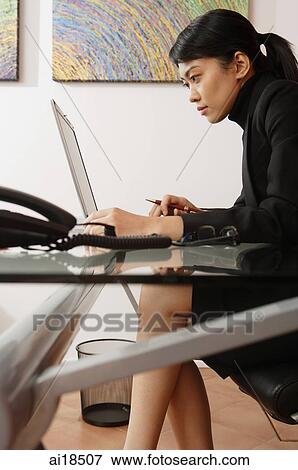 Female executive in office, using laptop View Large Photo Image Stock Photo - Female executive in office, using laptop. Fotosearch