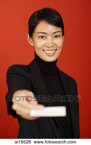 Stock Photograph - Female executive smiling and holding out business card. Fotosearch