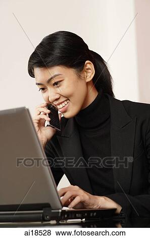 Female executive using laptop and using mobile phone View Large Photo Image Stock Photo - Female executive using laptop and using mobile phone. Fotosearch