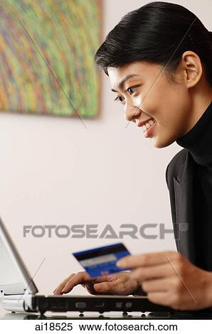 Female executive using laptop, holding credit card View Large Photo Image Stock Photography - Female executive using laptop, holding credit card. Fotosearch