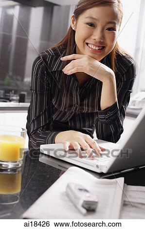 Female executive with laptop, hand on chin, smiling at camera View Large Photo Image Stock Photograph - Female executive with laptop, hand on chin, smiling at camera. Fotosearch