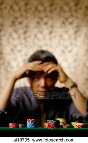 Gambling chips stacked in foreground, stressed man in background, hand on head View Large Photo Image Stock Photography - Gambling chips stacked in foreground, stressed man in background, hand on head. Fotosearch