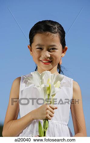 Girl holding bouquet of flowers, smiling at camera View Large Photo Image Stock Image - Girl holding bouquet of flowers, smiling at camera. Fotosearch