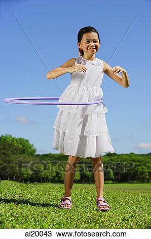Girl in park using hoola hoop View Large Photo Image Stock Image - Girl in park using hoola hoop. Fotosearch