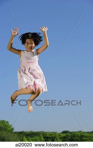 Girl in pink dress, jumping in mid air, smiling at camera View Large Photo Image Stock Image - Girl in pink dress, jumping in mid air, smiling at camera. Fotosearch