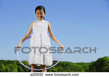 Girl in white dress, holding hoola hoop View Large Photo Image Stock Image - Girl in white dress, holding hoola hoop. Fotosearch