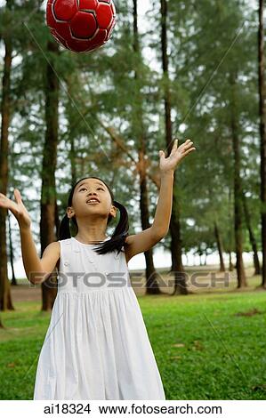 Girl in white dress, tossing ball in park View Large Photo Image Picture - Girl in white dress, tossing ball in park. Fotosearch