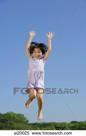 Girl jumping in mid air, arms outstretched, smiling View Large Photo Image Stock Photography - Girl jumping in mid air, arms outstretched, smiling. Fotosearch