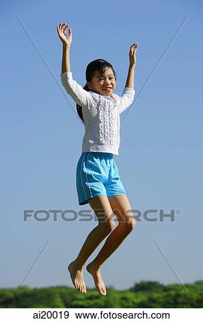 Girl jumping in mid air, smiling at camera View Large Photo Image Stock Photo - Girl jumping in mid air, smiling at camera. Fotosearch