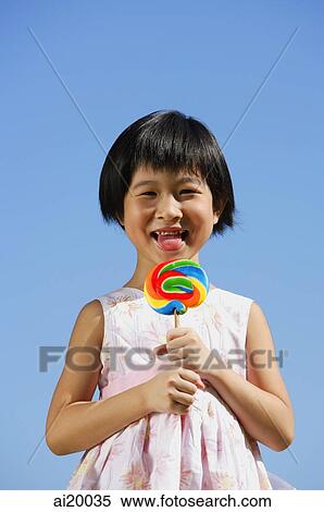 Girl licking lollipop, portrait View Large Photo Image Stock Photography - Girl licking lollipop, portrait. Fotosearch