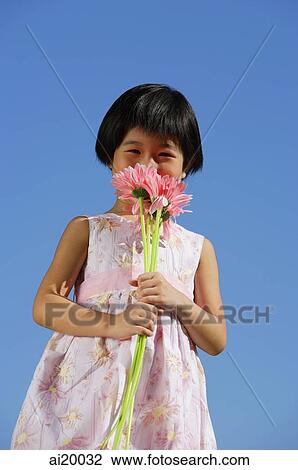 Girl smelling bouquet of flowers View Large Photo Image Stock Image - Girl smelling bouquet of flowers. Fotosearch