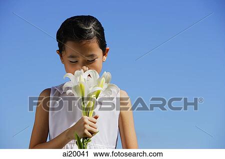 Stock Image - Girl smelling bouquet of flowers. Fotosearch