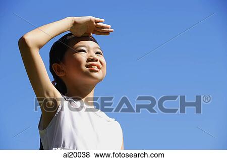 Girl standing outdoors, shielding eyes, looking away View Large Photo Image Stock Photo - Girl standing outdoors, shielding eyes, looking away. Fotosearch