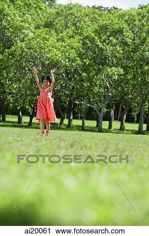 Girl walking in park, arms outstretched, smiling View Large Photo Image Stock Image - Girl walking in park, arms outstretched, smiling. Fotosearch