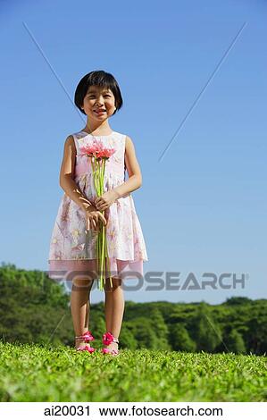 Girl wearing pink dress, holding bouquet of flowers View Large Photo Image Stock Image - Girl wearing pink dress, holding bouquet of flowers. Fotosearch