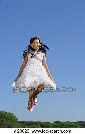 Girl wearing white dress, jumping in mid air View Large Photo Image Stock Photograph - Girl wearing white dress, jumping in mid air. Fotosearch