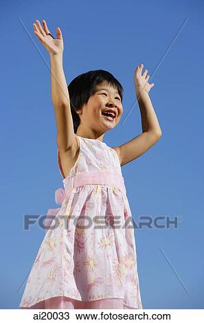 Girl with hands raised, smiling, looking away View Large Photo Image Stock Image - Girl with hands raised, smiling, looking away. Fotosearch