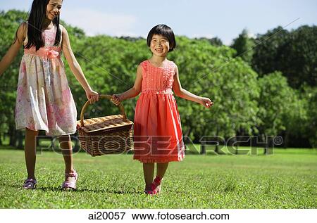 Girls in park, carrying picnic basket View Large Photo Image Stock Photo - Girls in park, carrying picnic basket. Fotosearch