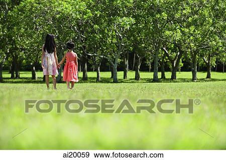 Stock Photo - Girls walking hand in hand in park. Fotosearch