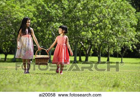 Girls walking in park, carrying picnic basket View Large Photo Image Stock Photo - Girls walking in park, carrying picnic basket. Fotosearch