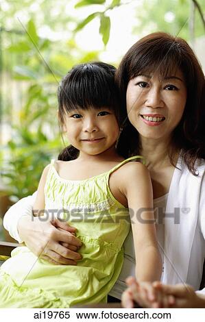 Stock Photography - Grandmother with arm around granddaughter, looking at camera. Fotosearch