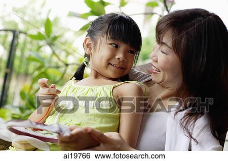 Stock Photograph - Grandmother with granddaughter, looking at each other. Fotosearch