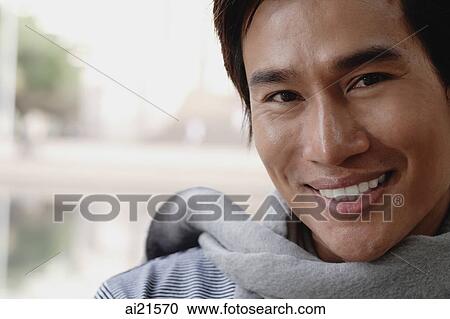 Stock Image - Head shot of man wearing scarf. Fotosearch
