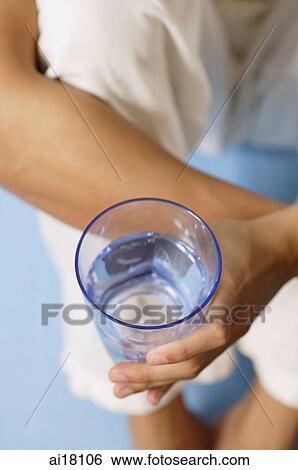 Stock Photograph - High angle view of man holding glass of water. Fotosearch