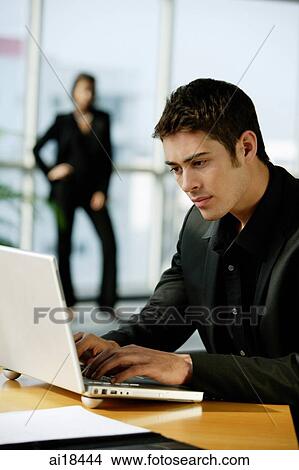 Male executive dressed in black, using laptop View Large Photo Image Picture - Male executive dressed in black, using laptop. Fotosearch