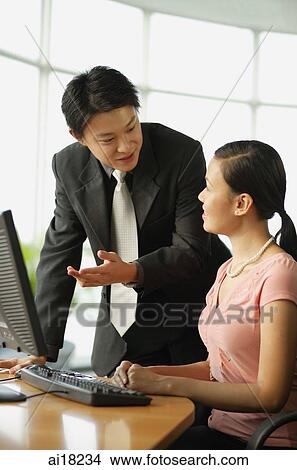 Picture - Male executive having a discussion with female executive. Fotosearch